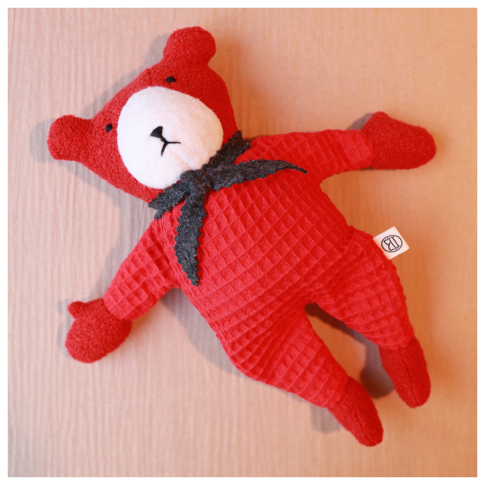 red teddy bear berry with grey scarf and white nose laying down