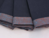 Close up of blueberry blue and reddish blue bordered linen napkins. Picture frame mitered corner boarder.