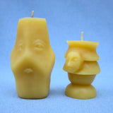 two faced candle next to beeheaded candle