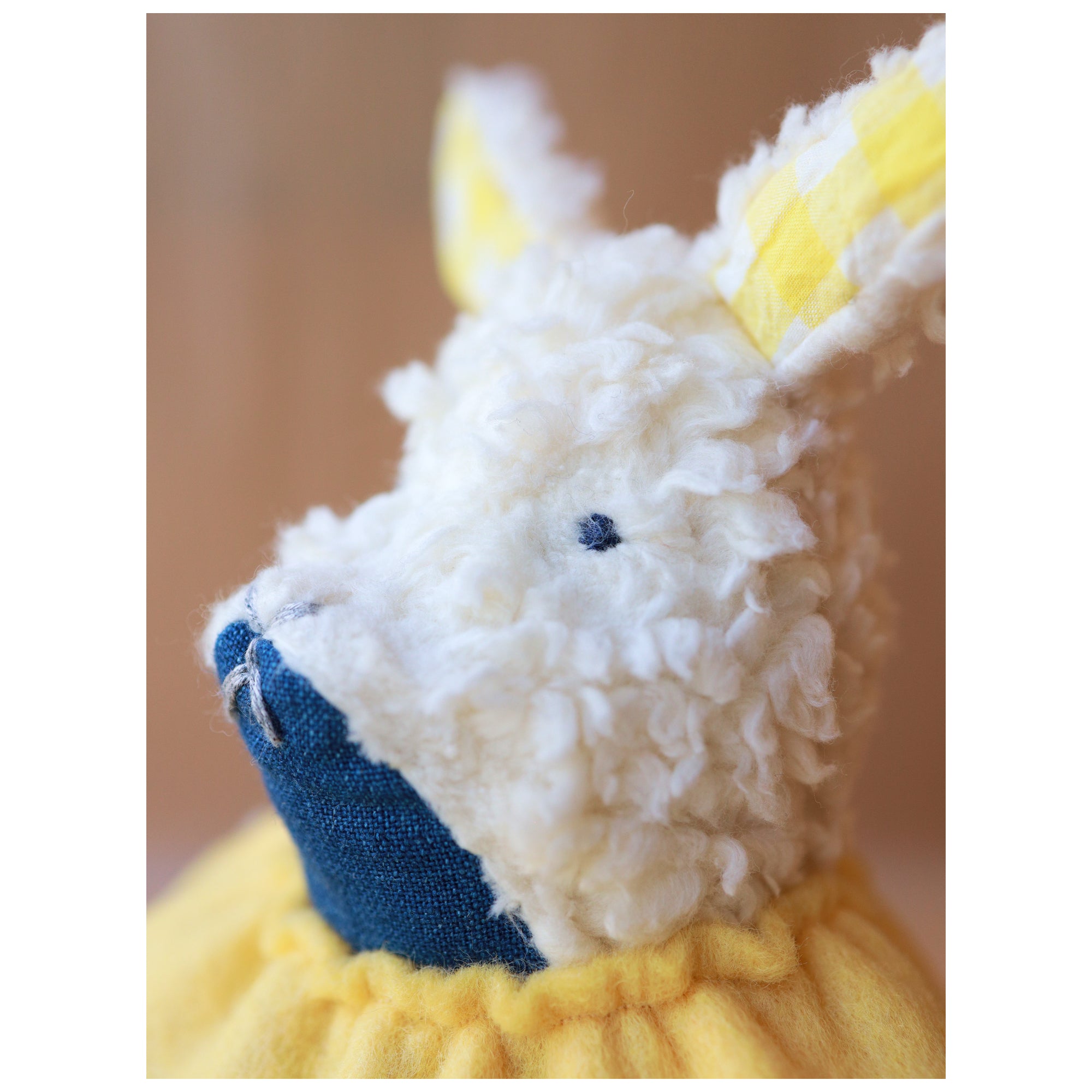 Close-up of a plush toy with white face and blue nose on a blurred background