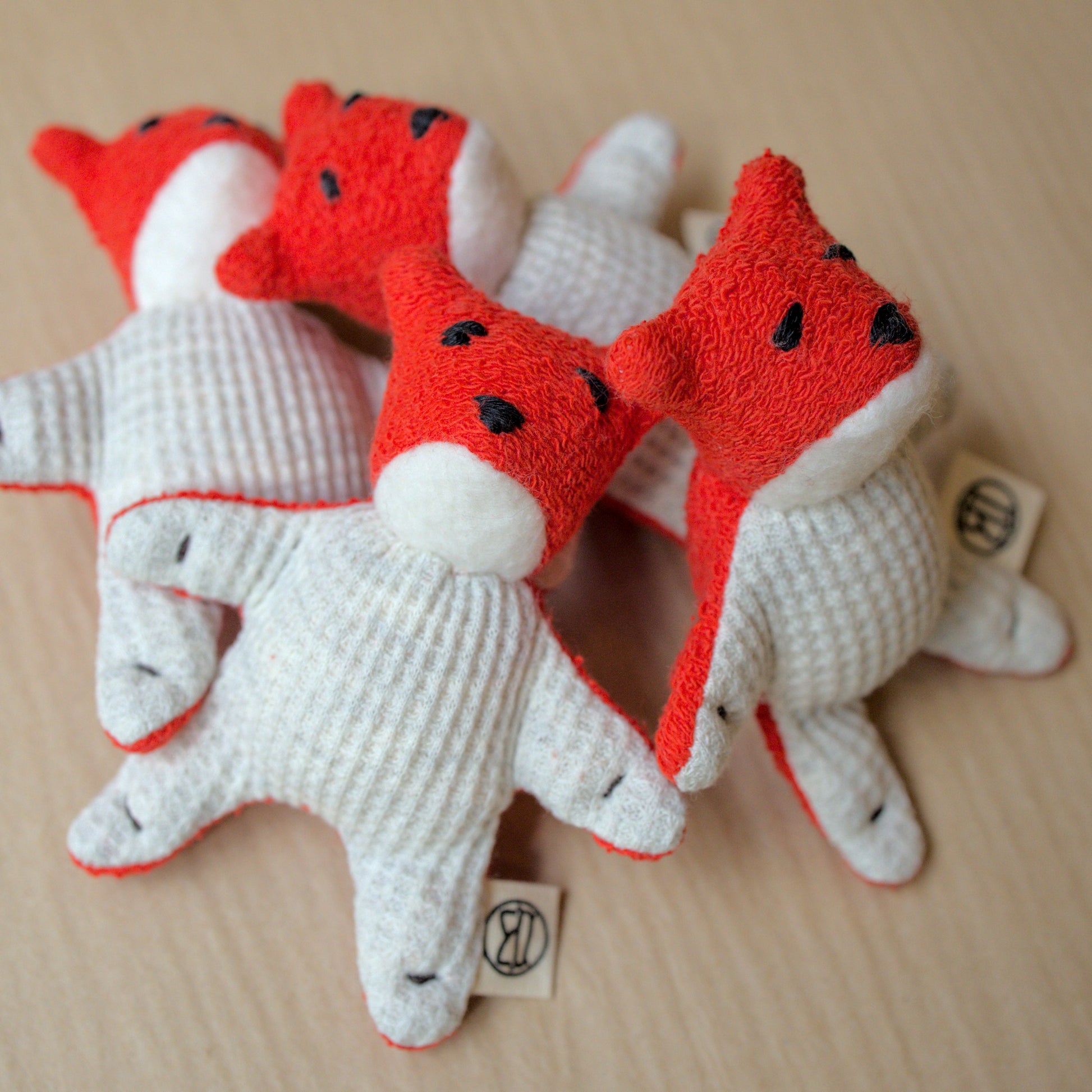 pile of mini fox toys made from red terrycloth, fleece and light gray waffle fabric
