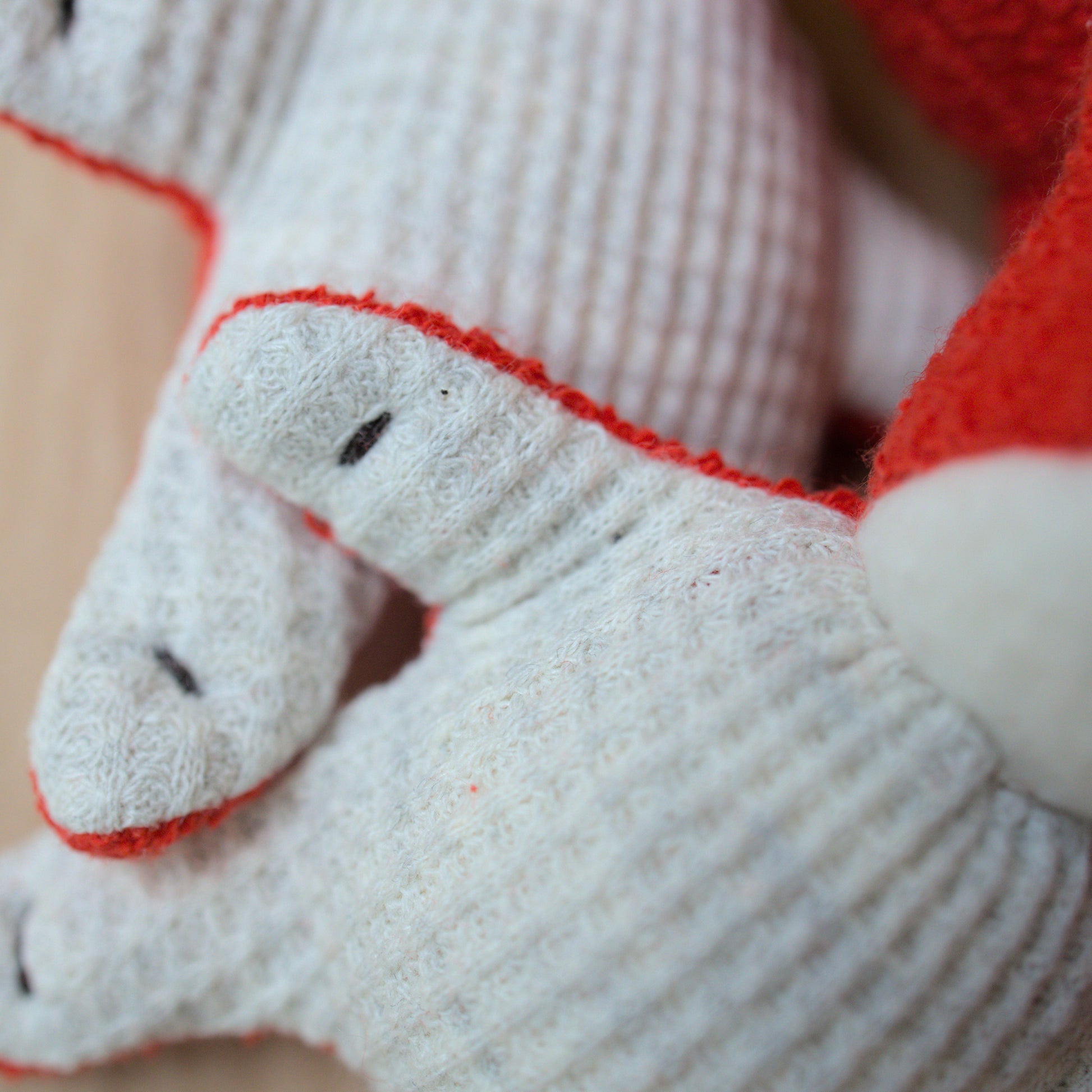 Close up of mini fox toy made from red terrycloth, fleece and light gray waffle fabric