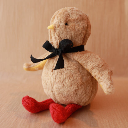stuffed toy chick with black ribbon and red legs. Brown cotton fur and yellow beak
