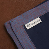 Close up on Made:Cozy tag on blueberry blue and reddish blue bordered linen napkins. Picture frame mitered corner boarder.