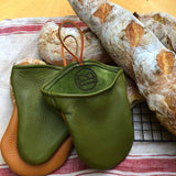 green and light brown oven mitt and baguetts