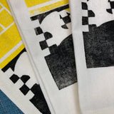 2 color print in black and yellow. The imagery is of sunshine coming through the kitchen window and hitting the black and white checkered floor. 